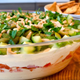 Mediterranean Seven-Layer Dip next to bowl of pita chips